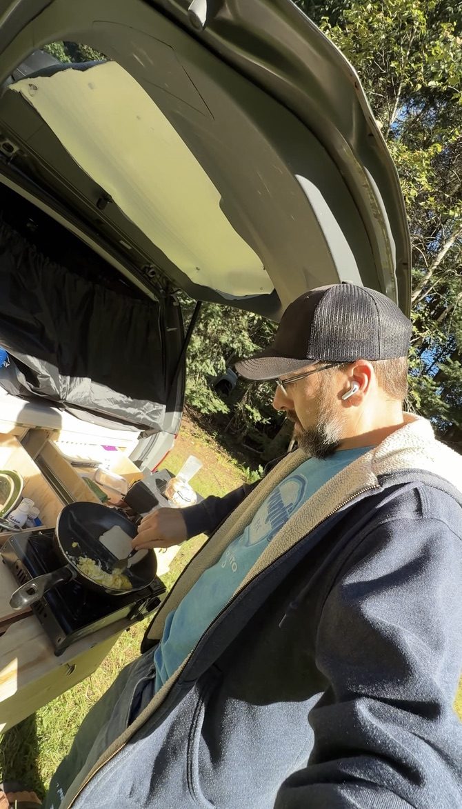 JM qui cuisine à l'arrière de sa minivan